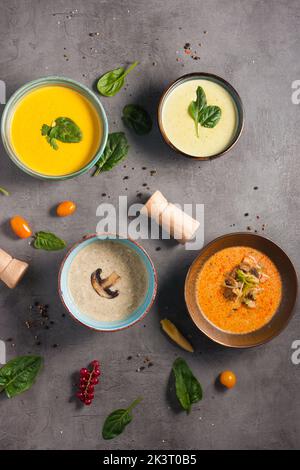 quattro zuppe diverse e gustose decorate con erbe aromatiche. Vista dall'alto Foto Stock