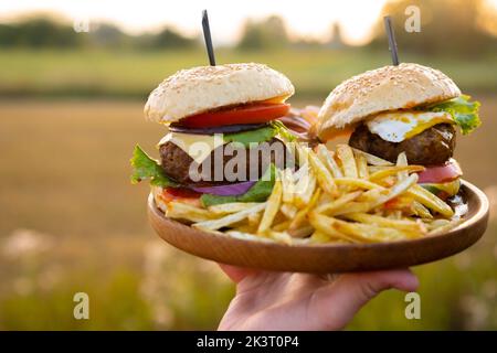 Due hamburger con cutlet di hamburger di manzo, cipolla fritta, salsa ketchup e formaggio Foto Stock