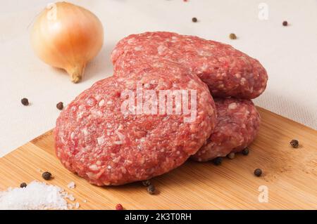 Cotolette di manzo con cipolle su un asse di legno Foto Stock