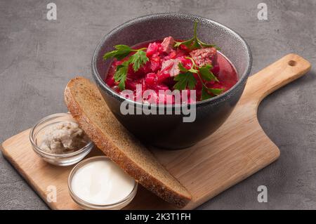 gustoso borscht di manzo con panna acida di strutto e pane nero Foto Stock