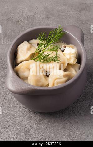 gustosi gnocchi in una pentola in brodo con burro e pepe nero Foto Stock