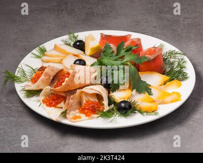 gustoso pesce assortito in un ristorante su un piatto bianco Foto Stock