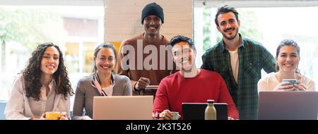 Banner o intestazione orizzontale con sorridenti colleghi multietnici che guardano la fotocamera facendo foto di squadra in un ufficio moderno insieme - gruppo di lavoro diversificato o. Foto Stock