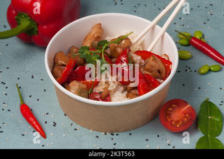 riso gustoso con pollo e peperone in un piatto artigianale Foto Stock