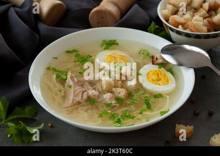 gustosa zuppa di pollo con tagliatelle, uova, erbe aromatiche e crostini Foto Stock