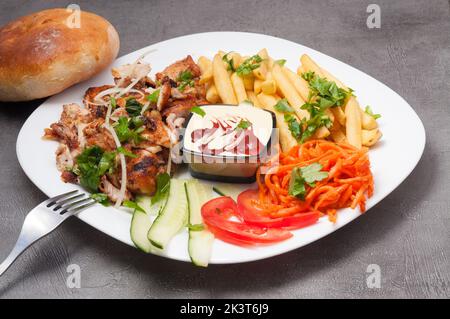 gustoso kebab doner o shawarma su un piatto con patatine fritte Foto Stock