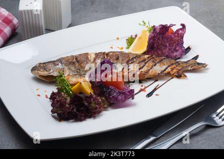 gustosa trota alla griglia con pomodori limone e lattuga Foto Stock
