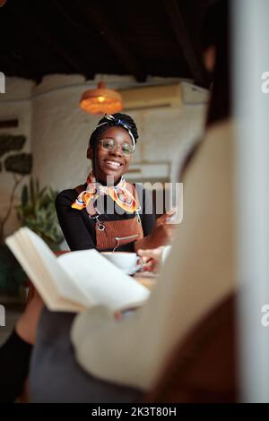 Due studentesse multiculturali sedute in caffetteria e studiano per un esame. Foto Stock