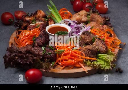 gustosi e assortiti kebab di shish con carote e salsa di pomodoro su un asse di legno Foto Stock