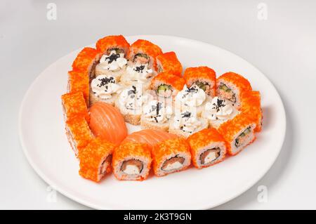 gustosi panini di sushi disposti a forma di cuore su un piatto bianco. Concetto: Amore per il sushi Foto Stock