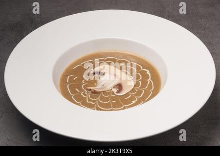 gustosa zuppa di panna con funghi in un piatto bianco Foto Stock