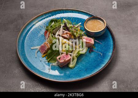 insalata gustosa con verdure, tonno fritto e salsa di senape al miele Foto Stock