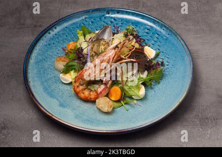 insalata gustosa con verdure, langostine, cozze e capesante decorate con uova di quaglia Foto Stock