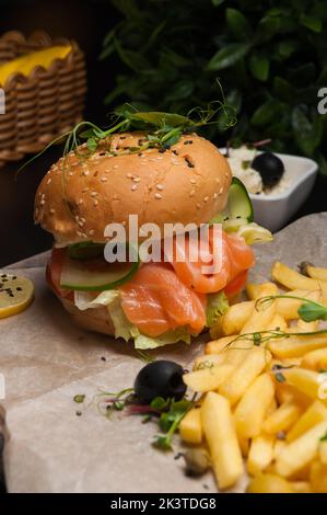 hamburger di pesce con salmone, verdure e patatine fritte Foto Stock