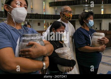 Manila, Filippine. 28th Set, 2022. Il sacerdote cattolico p. Flaviano ''Flavie'' Villanueva conforta i familiari e i parenti delle vittime della guerra alla droga durante un servizio commemorativo all'interno di una chiesa cattolica a Quezon City, Metro Manila, Filippine. Settembre 28, 2022. I resti sono stati esumati dalle loro tombe dopo il leasing sulle tombe in un cimitero pubblico sono stati sepolti scaduti e i parenti non potevano permettersi di continuare con esso. (Credit Image: © Basilio Sepe/ZUMA Press Wire) Foto Stock