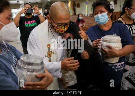 Manila, Filippine. 28th Set, 2022. Il sacerdote cattolico p. Flaviano ''Flavie'' Villanueva conforta i familiari e i parenti delle vittime della guerra alla droga durante un servizio commemorativo all'interno di una chiesa cattolica a Quezon City, Metro Manila, Filippine. Settembre 28, 2022. I resti sono stati esumati dalle loro tombe dopo il leasing sulle tombe in un cimitero pubblico sono stati sepolti scaduti e i parenti non potevano permettersi di continuare con esso. (Credit Image: © Basilio Sepe/ZUMA Press Wire) Foto Stock