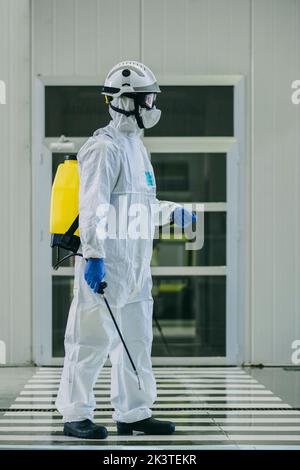 Vigili del fuoco che disinfetta pareti e pavimenti sulla strada Foto Stock