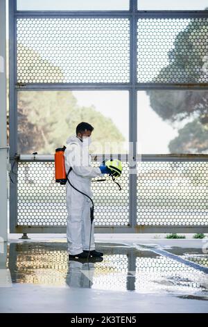 Vigili del fuoco che disinfetta pareti e pavimenti sulla strada Foto Stock