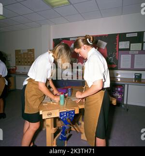 Adolescenti che lavorano in Panchina utilizzando colla in Woodwork Class Foto Stock