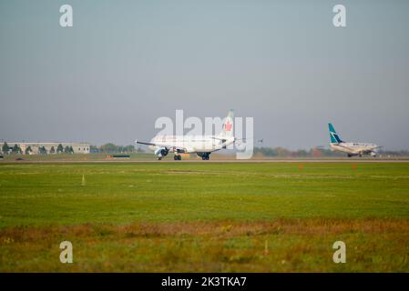 Un aeromobile commerciale a reazione Air Canada e un aeromobile commerciale WestJet che tassano presso l'aeroporto McDonald Cartier di Ottawa, Ottawa, Ontario, Canada Foto Stock