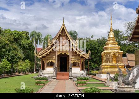 Splendida vista panoramica del viharn Lai Kham e stupa dorata all'interno del complesso del famoso monumento Wat Phra Singh tempio buddista, Chiang mai, Thailandia Foto Stock