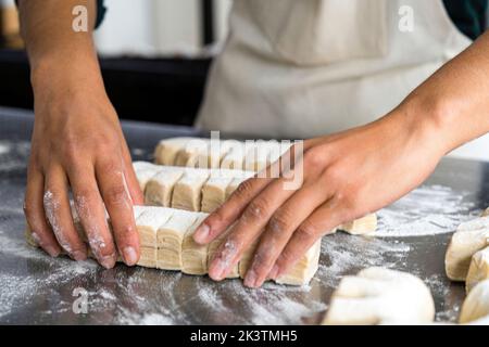 Primo piano di una pasta da forno femminile Foto Stock