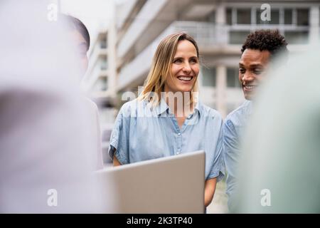 Vista frontale di diversi colleghi che si prendono tempo dal lavoro in un ambiente all'aperto Foto Stock