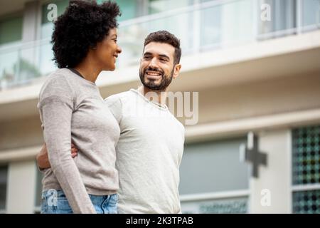 Felice giovane coppia adulta che cammina sul marciapiede Foto Stock