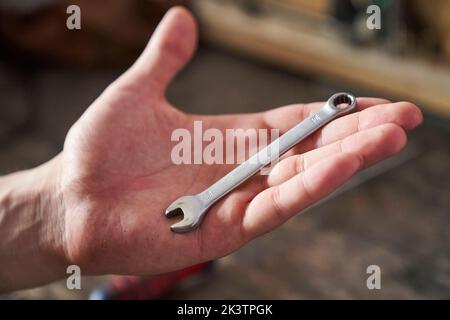 Primo piano della chiave combinata sul palmo della mano di una persona Foto Stock