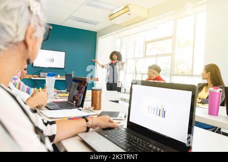 Compagnia di colleghi multietnici che si riuniscono in un moderno spazio di coworking e discutono insieme il progetto di startup in Costa Rica Foto Stock