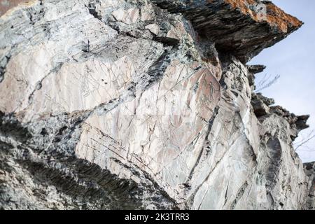 Antiche incisioni rupestri di un antico uomo sulle rocce della Siberia. I disegni raffigurano animali e persone Foto Stock