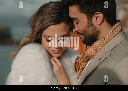 Vista laterale di bell'uomo positivo bearded vicino affascinante bella donna in sera indossare con gli occhi chiusi Foto Stock