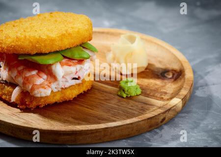 Cucina panasiatica. Hamburger di sushi giapponese a base di pane di riso, carne di granchio, avokado e salsa wasabi. Servizio su asse di legno. Spazio per fotocopie Foto Stock