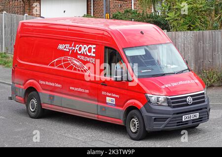 Parcelforce Worldwide Courier & Logistics service un nome commerciale di Royal Mail Postal Service rosso VW furgone e conducente consegna pacchi nel villaggio del Regno Unito Foto Stock