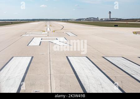 Pista 21R all'aeroporto metropolitano di Detroit Wayne County (DTW) a Detroit, Michigan, USA, con la torre di controllo e i terminali sullo sfondo. Foto Stock