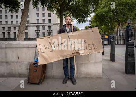 Londra, Regno Unito. 28th Settembre 2022. Un manifestante solista si trova di fronte a Downing Street e mostra il cartello “l’Inghilterra non è razzista”. Originario dell’Iran, “ben” sostiene di essere stato vittima di ripetuti abusi razziali da quando è arrivato nel Regno Unito 14 mesi fa, mentre si è spostato tra le aree di Londra e Manchester. Credit: Guy Corbishley/Alamy Live News Foto Stock