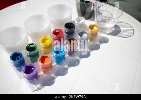 12 vasetti colorati alla luce del sole pronti per la verniciatura e la miscelazione Foto Stock