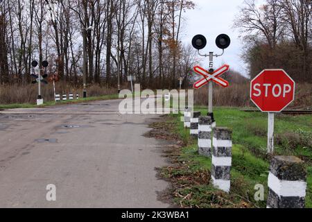 Attraversamento ferroviario con segnale di stop e semaforo. Foto Stock