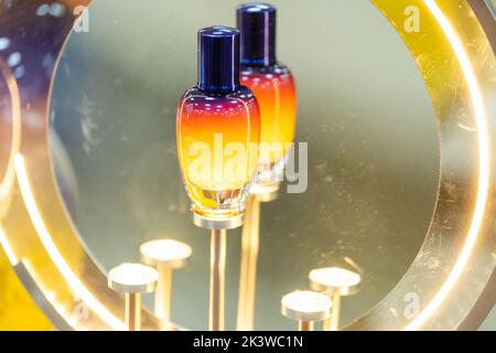 Bella spruzzatrice in vetro in piedi. Composizione del concetto cosmetico autunnale. Presentazione di un campione di profumo di legno. Pubblicità di prodotti di lusso Foto Stock