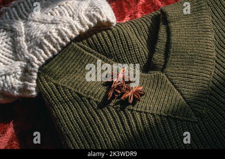 Immagine di un maglione di lana verde dell'esercito e di un cappello di lana alla luce del sole Foto Stock