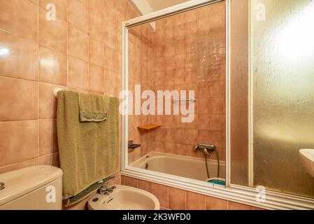 Bagno con cabina doccia con accenti bianchi e piastrelle marroni Foto Stock