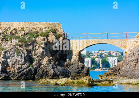 Es Pujolar sulla spiaggia di Cala Major, un piccolo ponte verso una piccola isola vicino alla costa. Sullo sfondo la città di CAS Catala o Ses Illetes Foto Stock