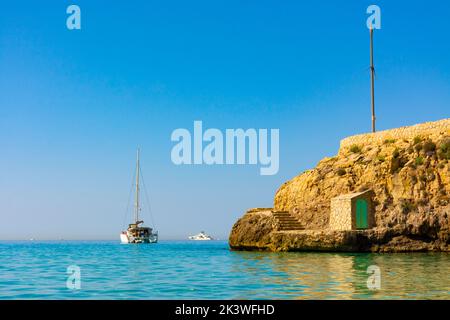 Palma, Maiorca, Spagna. Una barca a vela ormeggiata alla spiaggia di Cala Major, vicino all'isola di es Pujolar Foto Stock