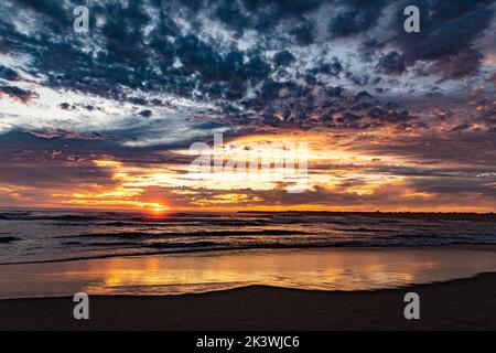 Un bellissimo scatto di una spiaggia durante il tramonto Foto Stock