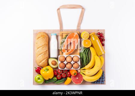 Cibo sano sfondo. Cibo sano in borsa riutilizzabile verdure, frutta, pesce, yogurt bianco. Shopping supermercato, consegna cibo con Foto Stock