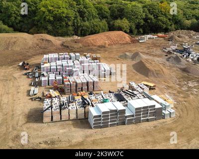 Pontypridd, Galles - Agosto 2022: Veduta aerea dei materiali da costruzione immagazzinati sul sito di un nuovo sviluppo di alloggi da parte dello sviluppatore Bellway Homes Foto Stock