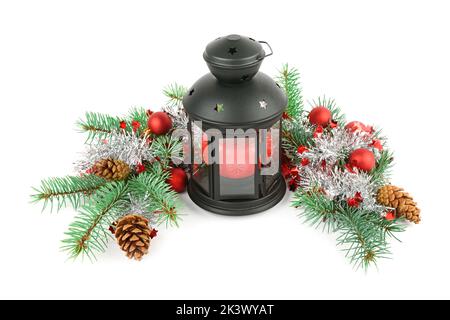 Composizione delle decorazioni natalizie . Ornamenti luminosi, lanterna a mano e rami di abete rosso isolati su sfondo bianco. Foto Stock