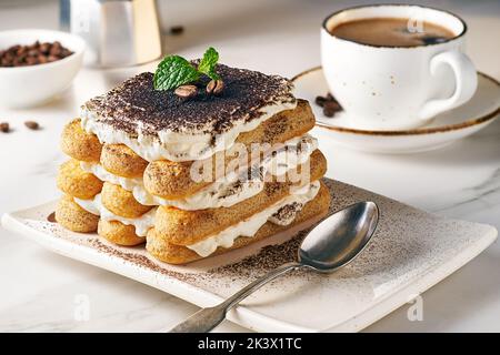 Delizioso tiramisù servito su piatto bianco Foto Stock