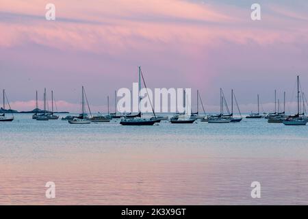 Pastello Rainbow Sky con barche ormeggiate e isola Foto Stock