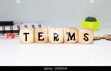 I termini firmano in un ufficio luminoso su una scrivania di legno con le finestre sullo sfondo. Foto Stock